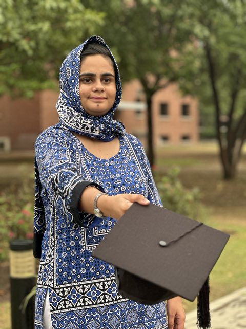 Wardah Noor on her LUMS graduation day, holding her mortarboard